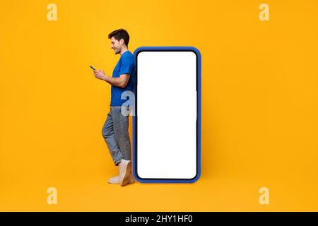 Man leaning on white blank smartphone screen, using cellphone Stock Photo