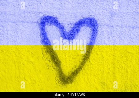 The symbol of the national flag of Ukraine in the form of a heart on a cracked concrete wall. Concept. Stock Photo