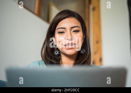 Focused student talking through her computer in class. Stock Photo