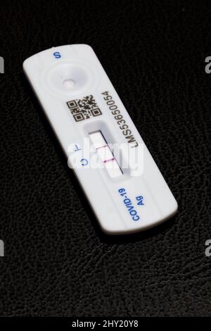 Positive Covid 19 lateral flow test / rapid lateral flow antigen coronavirus test on a black background  showing both bars on the test strip Stock Photo