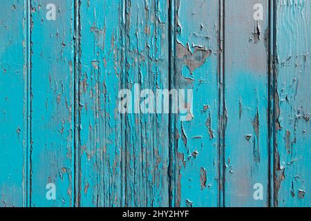 Blue paint peeling off of an old wooden surface texture Stock Photo