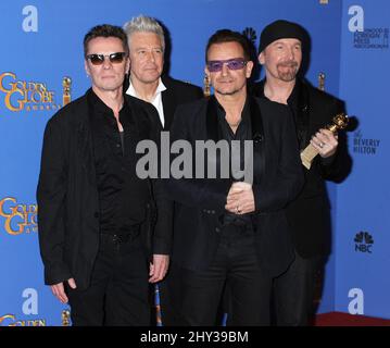 (left to right) Larry Mullen Jr., Adam Clayton, Bono and The Edge of U2 pose in the press room with the award for best original song for 'Ordinary Love' from the film 'Mandela: Long Walk to Freedom' at the 71st annual Golden Globe Awards at the Beverly Hilton Hotel on Sunday, Jan. 12, 2014, in Beverly Hills, Calif. Stock Photo