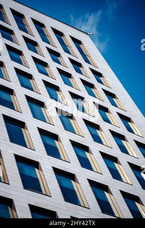 Facade of a modern building with a simple angular design against a blue ...