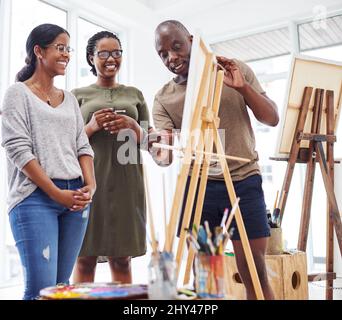 Our friends recommended this art class. Shot of a group of people discussing something in a art class. Stock Photo