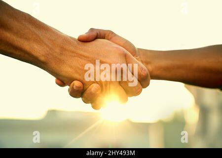 Come together, do great things. Cropped shot of two people shaking hands outdoors. Stock Photo