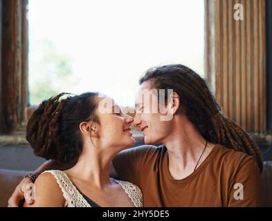 Dread-lock love. Shot of an affectionate dread-locked couple sitting at home. Stock Photo