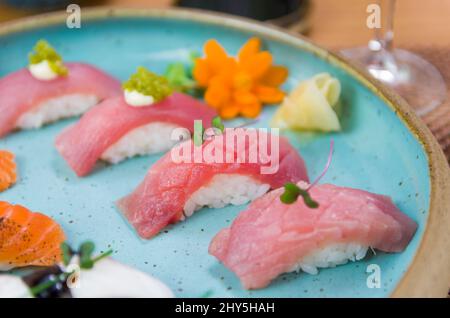 Assorted premium tuna and salmon nigiri sushi on a beautifully decorated plate. Stock Photo