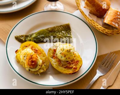 Twice baked potatoes stuffed with meat, jam, cheese and egg Stock Photo