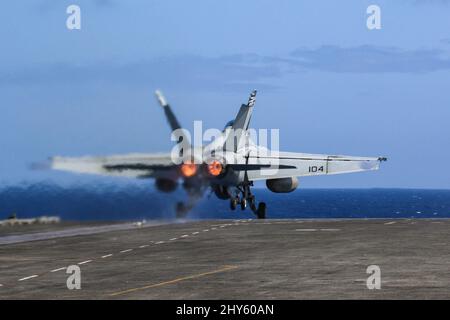 PHILIPPINE SEA (March 13, 2022) An F/A-18F Super Hornet, assigned to the 'Black Aces' of Strike Fighter Squadron (VFA) 41, launches from the flight deck of the Nimitz-class aircraft carrier USS Abraham Lincoln (CVN 72). Abraham Lincoln Strike Group is on a scheduled deployment in the U.S. 7th Fleet area of operations to enhance interoperability through alliances and partnerships while serving as a ready-response force in support of a free and open Indo-Pacific region. (U.S. Navy photo by Mass Communication Specialist Seaman Apprentice Julia Brockman) Stock Photo