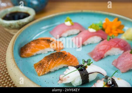Assorted premium tuna and salmon nigiri sushi on a beautifully decorated plate. Stock Photo