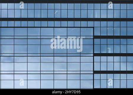 Bellevue, WA, USA - March 13, 2022; Modern office building with glass facade reflecting blue gray sky in a series of repeating patterns of squares Stock Photo