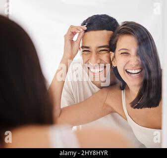 We both woke up on the right side of the bed. Shot of a happy young couple standing together in their bathroom in the morning. Stock Photo