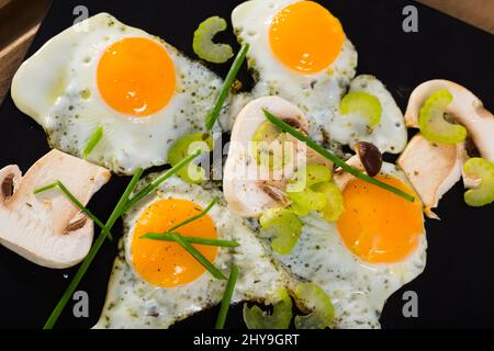 Fried quail eggs with champignons Stock Photo