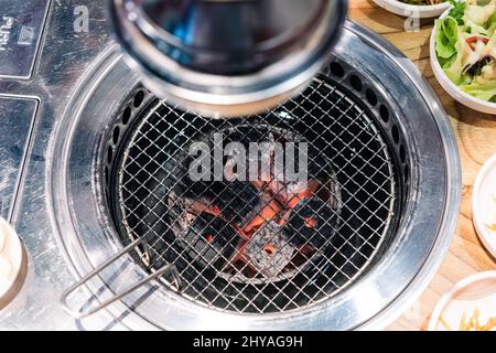 Korean BBQ stove and smoke hood. grill to place the meat to grill and below lit with charcoal at restaurant Stock Photo