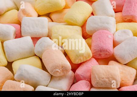 Closeup view pile of colorful marshmallows. Texture of fluffy mini marshmallows. Group of delicious multicolor mini marshmallow. Stock Photo