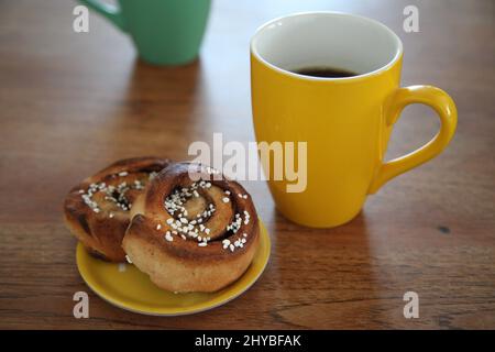 Kopenhagen, Denmark. 14th Mar, 2022. Two cinnamon buns lie next to a coffee mug. A secret ingredient of Swedish happiness is found in the daily coffee break at work. Credit: Steffen Trumpf/dpa/Ģ����ý Live News Stock Photo