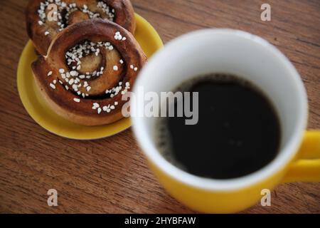Kopenhagen, Denmark. 14th Mar, 2022. Two cinnamon buns lie next to a coffee mug. A secret ingredient of Swedish happiness is found in the daily coffee break at work. Credit: Steffen Trumpf/dpa/Ģ����ý Live News Stock Photo