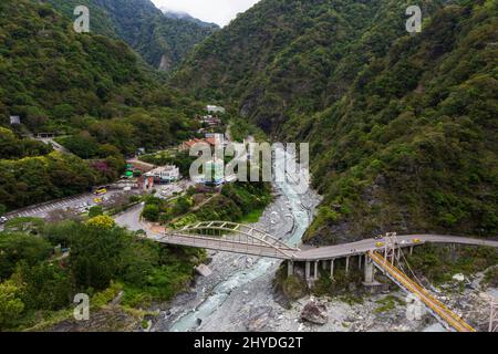 Tianxiang Recreation Area village next to rocky river and lush and steep mountains at the Taroko National Park in Taiwan, viewed from above. Stock Photo