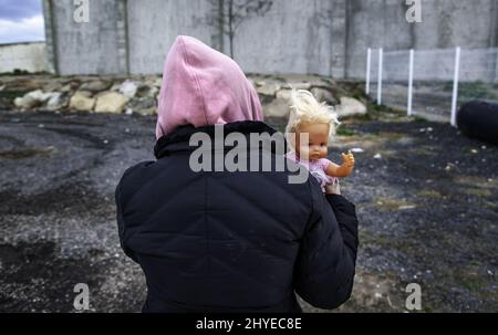 Broken doll among rubble, war childhood destroyed Stock Photo