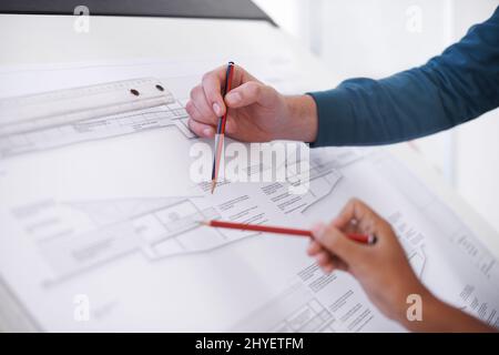 Its all about precision. Cropped shot of two architects working on a building plan at a drawing board. Stock Photo