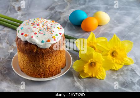 Easter cake and colorful Easter eggs with daffodil flowers. Traditional orthodox christian easter food. Stock Photo