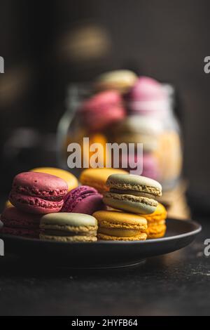 Sweet colorful macarons. Traditional french macaroons. Tasty dessert on the plate. Stock Photo