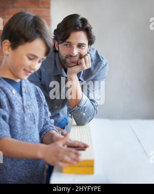 Helping dad with his woodwork. A father and son doing woodwork together. Stock Photo