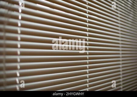 Blinds on window. White blinds cover window from sun. Interior details. Shooting diagonally. Stock Photo