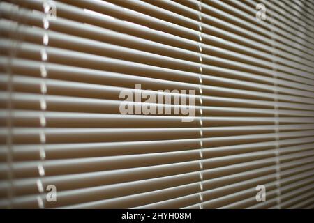 Blinds on window. White blinds cover window from sun. Interior details. Shooting diagonally. Stock Photo