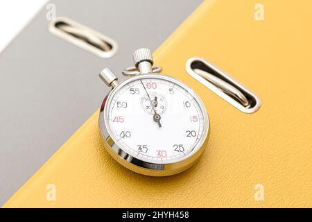 Yellow office folder on the chronometer. Stock Photo