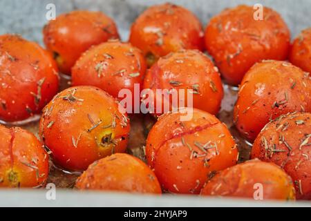Cherry tomatoes are ready after baking in the oven for appetizer with ricotta cheese and cherry tomatoes. Stock Photo