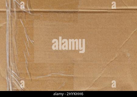 Worn cardboard texture with clear tape Stock Photo