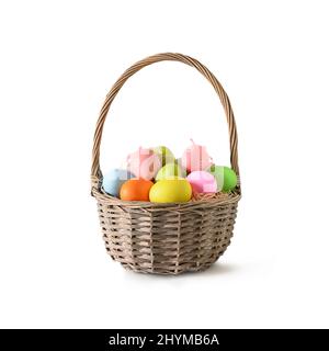 Easter wicker basket with pastel colorful eggs decorated isolated on white background. Festive Christianity religion tradition. Stock Photo