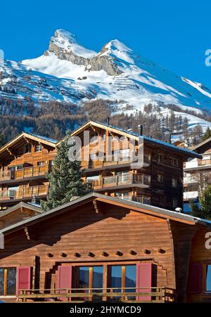 Valais chalets and holiday homes under the snow-capped Pointe de Chemo peak, Ovronnaz, Valais, Switzerland Stock Photo