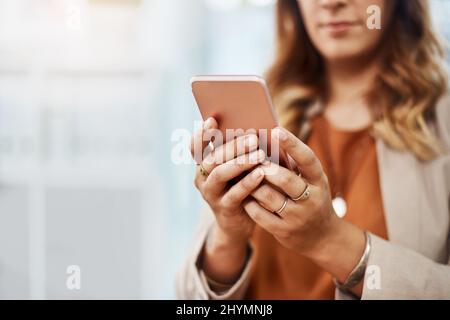 Following up on few business leads. Shot of an unrecognizable businesswoman using a cellphone while working in her office. Stock Photo