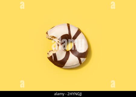 Black and white chocolate donut on yellow background Stock Photo