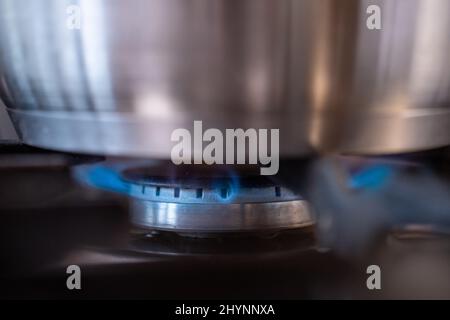 Close-up of gas burning under a cooking pan on a stove in the kitchen. Stock Photo