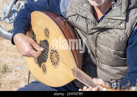 Old man playing exotic string instrument: Turkish oud. Stock Photo