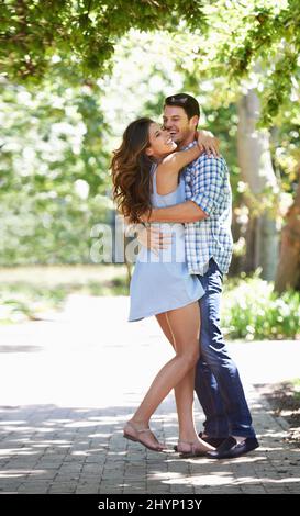 Playful romantics. Full length shot of a young couple embracing in the park. Stock Photo