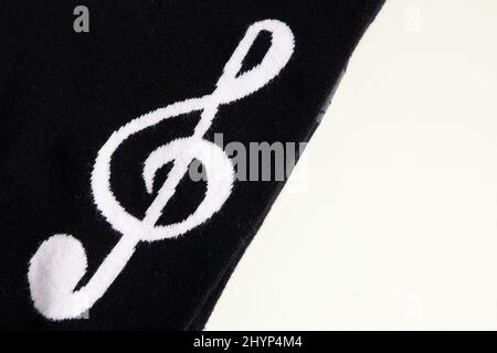 Embroidered treble clef on black textile. Stock Photo