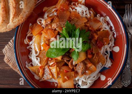 Hot Uighur dish served with herbs and flatbread. Stock Photo