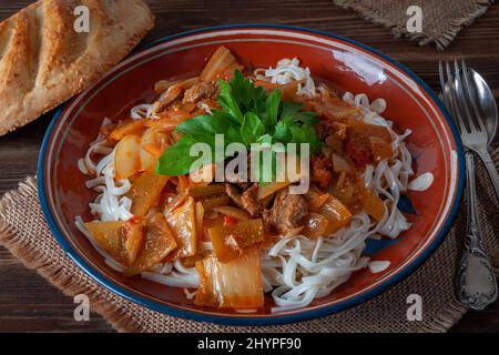 Hot Uighur dish served with herbs and flatbread. Stock Photo
