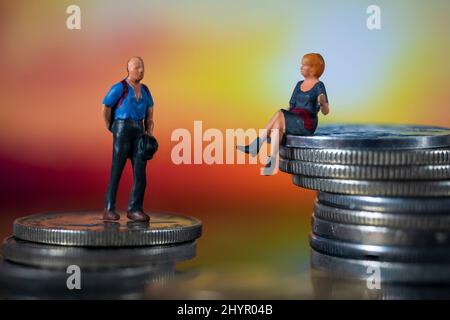 Miniature people, small figures businessmen and woman on top of coins. Money and Financial, Business Growth concept. Stock Photo