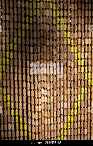 Traditional door curtain on Spanish house made from wine bottle corks to help keep flies out and to provide shade Stock Photo