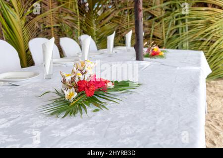 Set table with flowers on a beautiful beach. Stock Photo