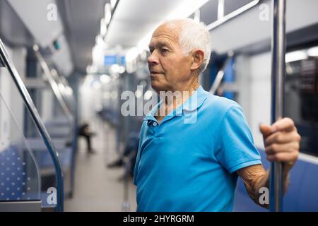 Elderly man in subway train Stock Photo