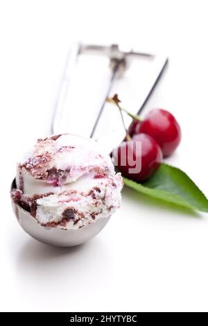 A scoop of fruit ice cream with fresh cherries