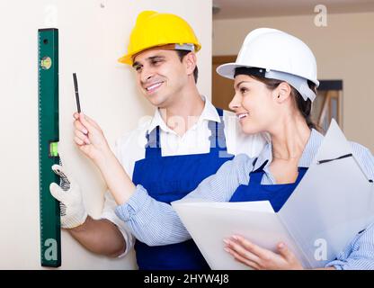 specialist and assistant working with wall in new building Stock Photo ...
