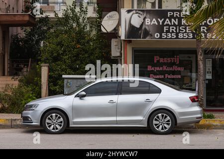 Side, Turkey -February  18, 2022:  white  Volkswagen Passat    is parked  on the street on a warm  autumn  day against the backdrop of a street,  shop Stock Photo