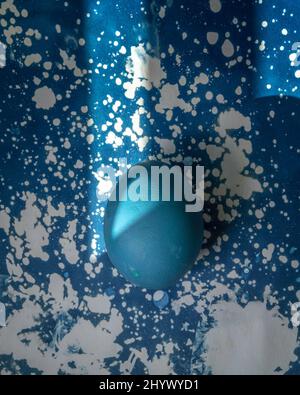 Still-life of a dyed egg on a Cyanotype background. Stock Photo